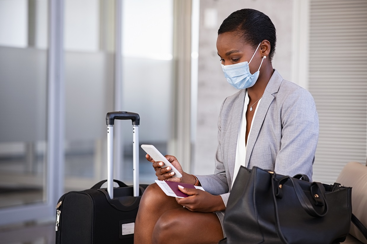 Mulher olha o celular no aeroporto.